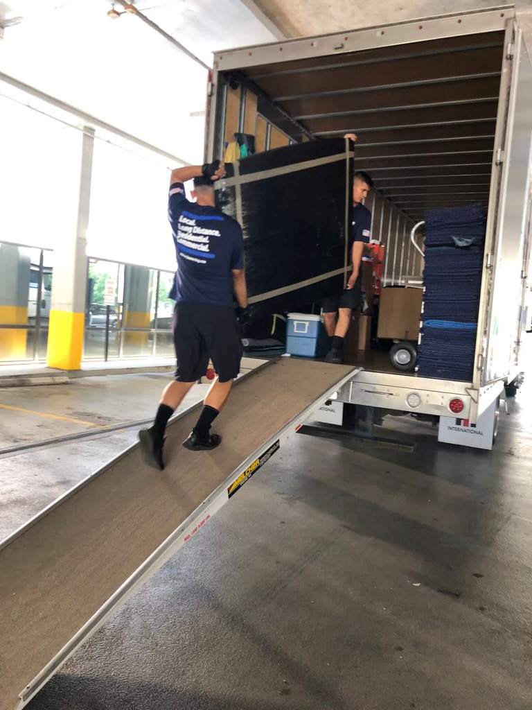 two HuberWilmot Movers loading a moving truck